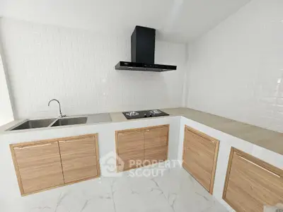 Modern kitchen with sleek cabinetry and gas stove in a bright, tiled space.
