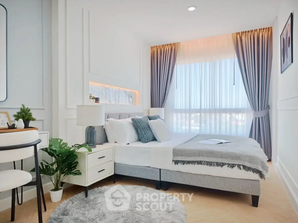 Elegant bedroom with modern decor and large window, featuring cozy bed and stylish furnishings.