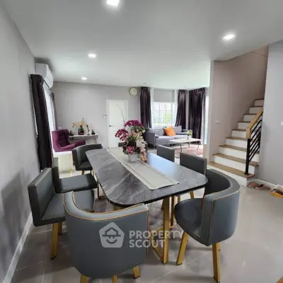 Modern dining area with elegant table and chairs, open layout to living room, stylish decor and natural light.