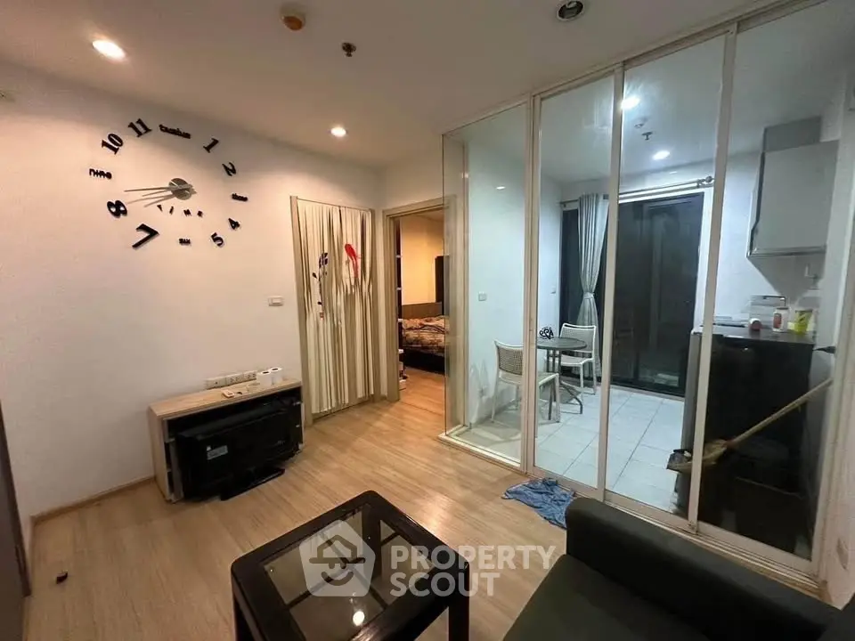 Modern living room with glass partition and stylish wall clock in cozy apartment.