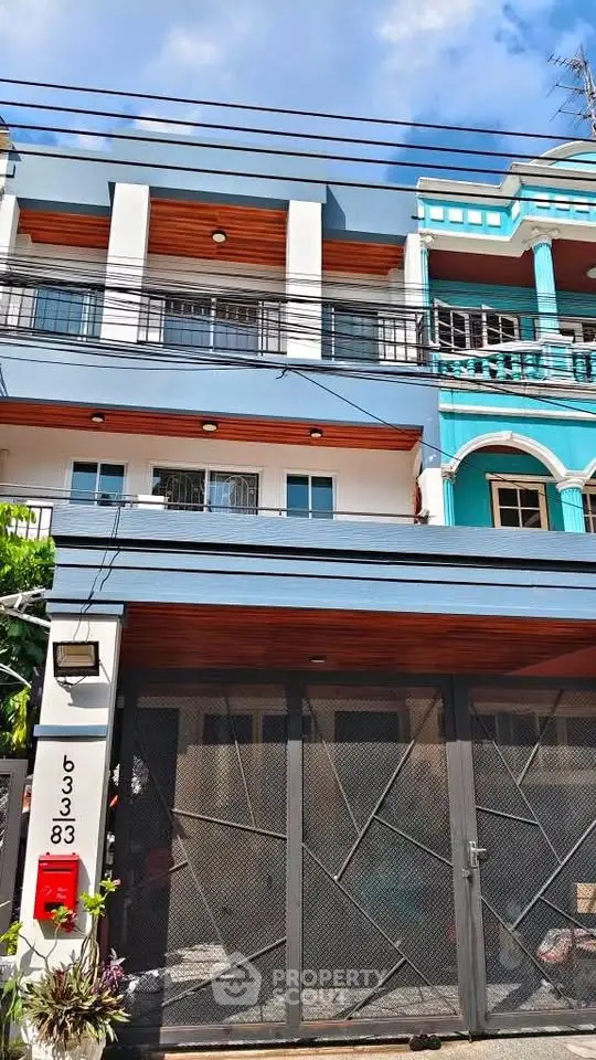 Modern multi-story townhouse with stylish facade and secure gated entrance.