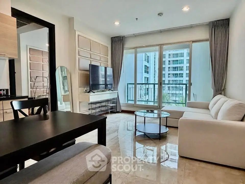 Modern living room with large windows and stylish furniture in a high-rise apartment.