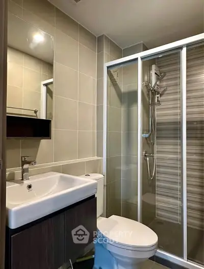 Modern bathroom with sleek shower enclosure and stylish vanity in contemporary apartment.