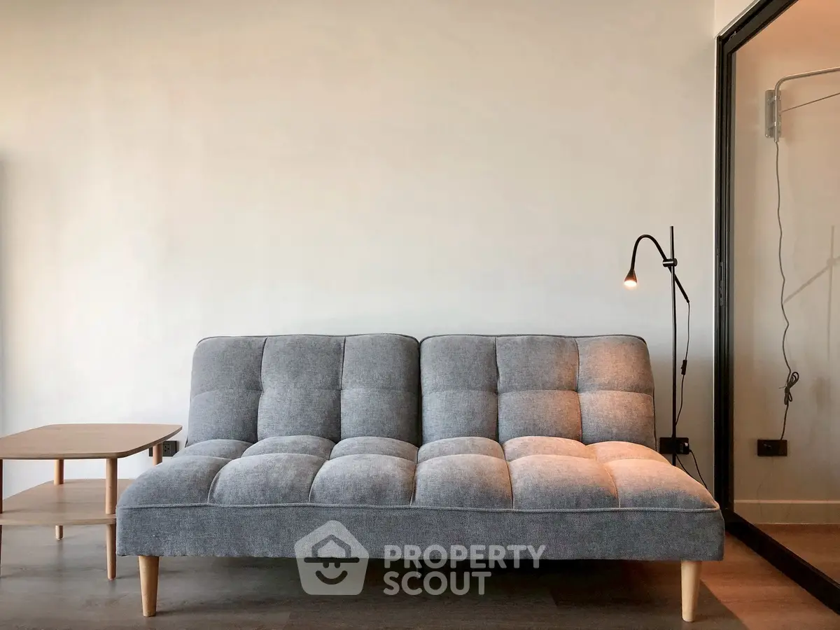 Modern living room with stylish gray sofa and sleek floor lamp