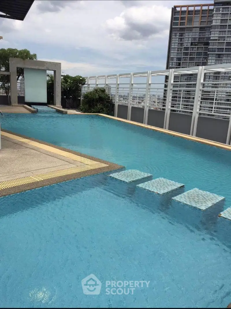 Luxurious rooftop pool with stunning city views in modern high-rise building.