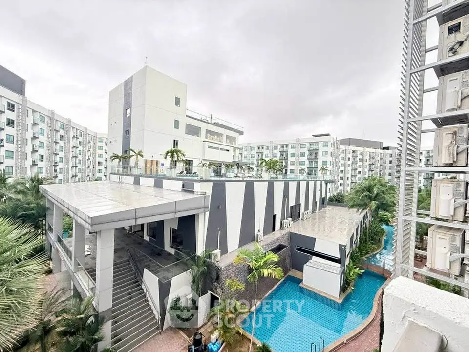 Modern apartment complex with pool and lush greenery, offering a serene urban living experience.
