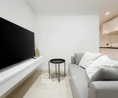 Modern living room with sleek TV, gray sofa, and minimalist decor