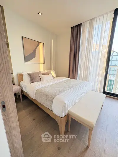 Elegant bedroom with modern decor and large windows offering natural light