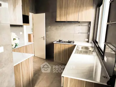 Modern kitchen with sleek wooden cabinets and gas stove in a stylish home.