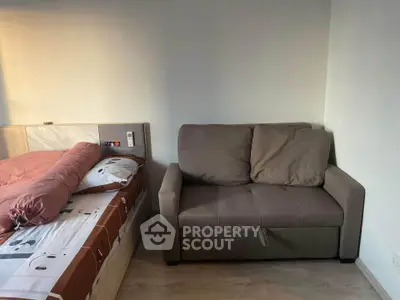 Cozy bedroom with modern bed and comfortable sofa, perfect for relaxation.