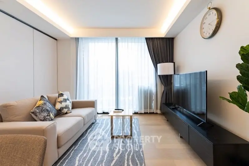 Modern living room with stylish decor, large TV, and natural light from floor-to-ceiling windows.