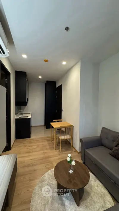 Modern living room with cozy seating and dining area in a stylish apartment.