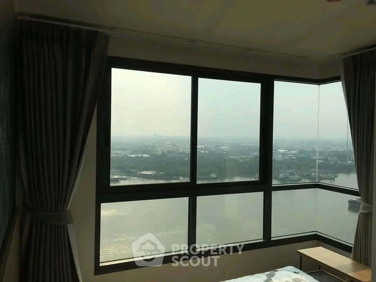 Stunning high-rise bedroom with panoramic river view and large windows.