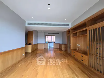Spacious living room with wooden flooring and built-in storage in modern apartment