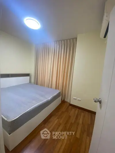 Cozy bedroom with wooden flooring and soft lighting