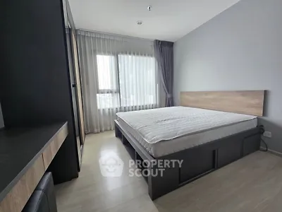 Modern minimalist bedroom with large window and sleek furnishings