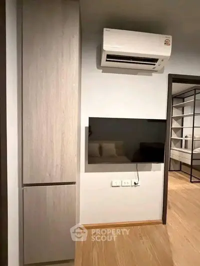 Modern interior with sleek TV setup and air conditioning in a stylish apartment.