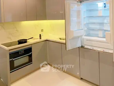 Modern kitchen with sleek cabinetry, built-in oven, and open fridge showcasing contemporary design.