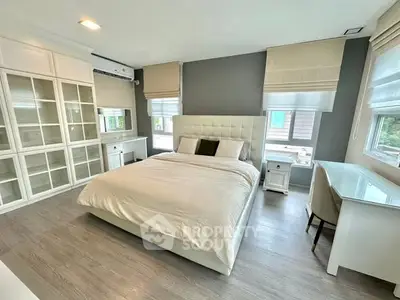 Spacious modern bedroom with elegant furnishings and ample natural light.