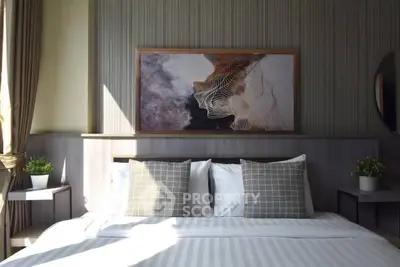 Luxurious bedroom with modern decor and elegant artwork, featuring plush bedding and stylish pillows.