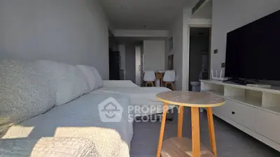 Modern living room with cozy sofa, stylish coffee table, and sleek TV setup in a bright apartment.