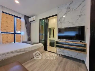 Modern bedroom with TV and marble accent wall in stylish apartment