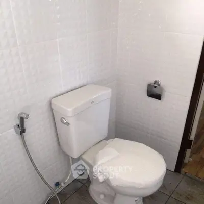 Modern bathroom with white tiled walls and sleek toilet design