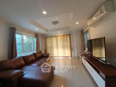 Spacious living room with leather sofa and large windows for natural light