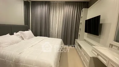 Modern bedroom with elegant curtains and wall-mounted TV, perfect for relaxation and comfort.