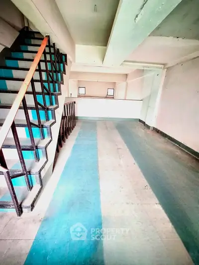 Spacious open-plan interior with staircase and natural light, ideal for customization.