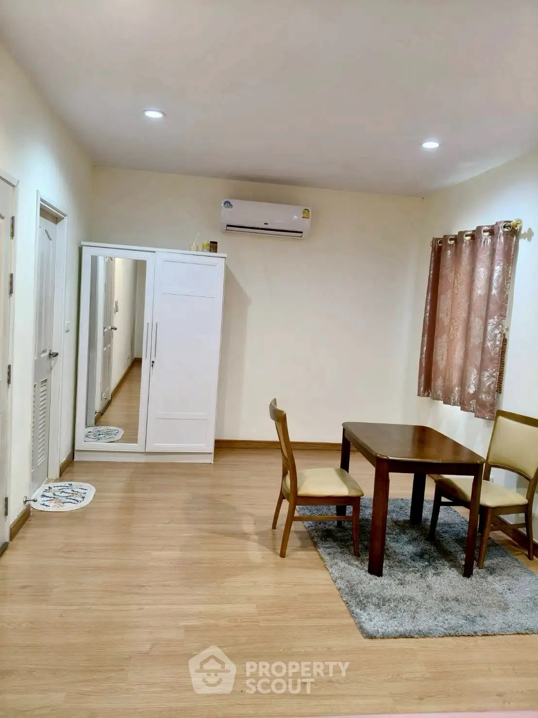Cozy dining area with wooden flooring and air conditioning in modern apartment.
