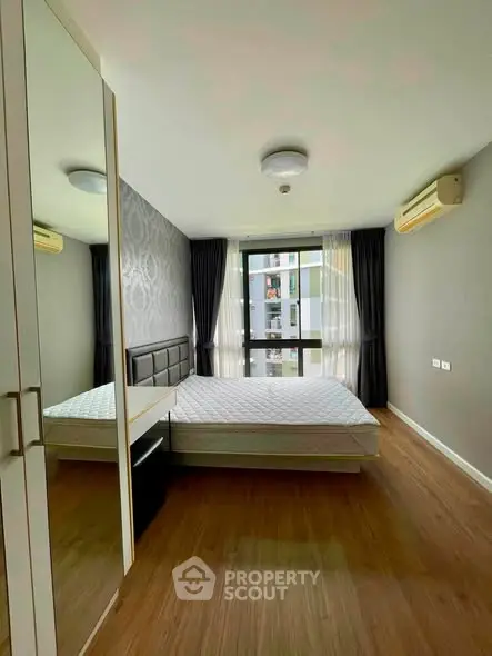 Modern bedroom with large window and stylish decor in urban apartment