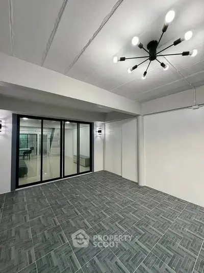 Spacious modern interior with stylish lighting and tiled flooring, perfect for versatile living or office space.