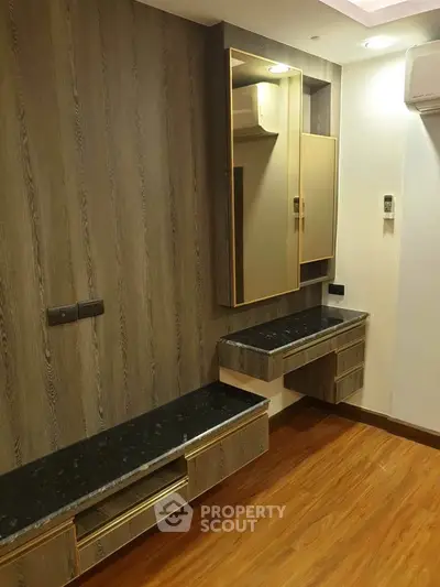 Modern bedroom with stylish wooden paneling and built-in storage solutions.