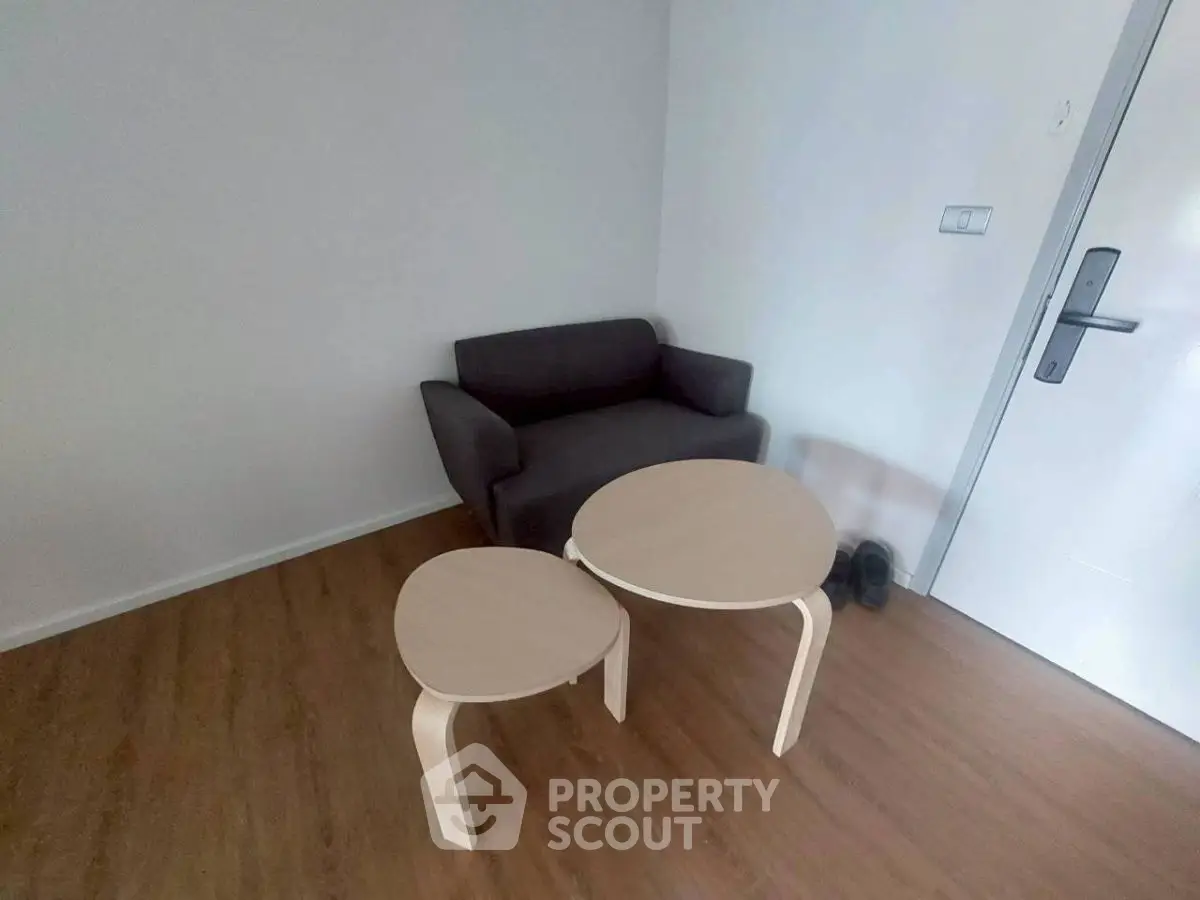 Cozy small living area with modern furniture and wooden flooring.