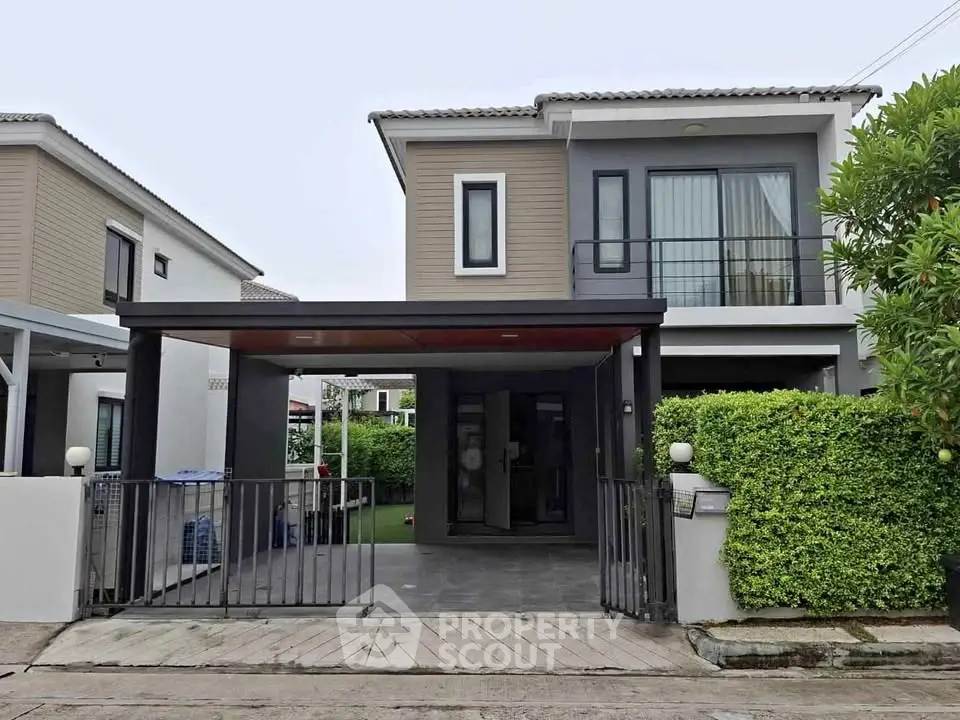 Modern two-story house with sleek design and lush greenery