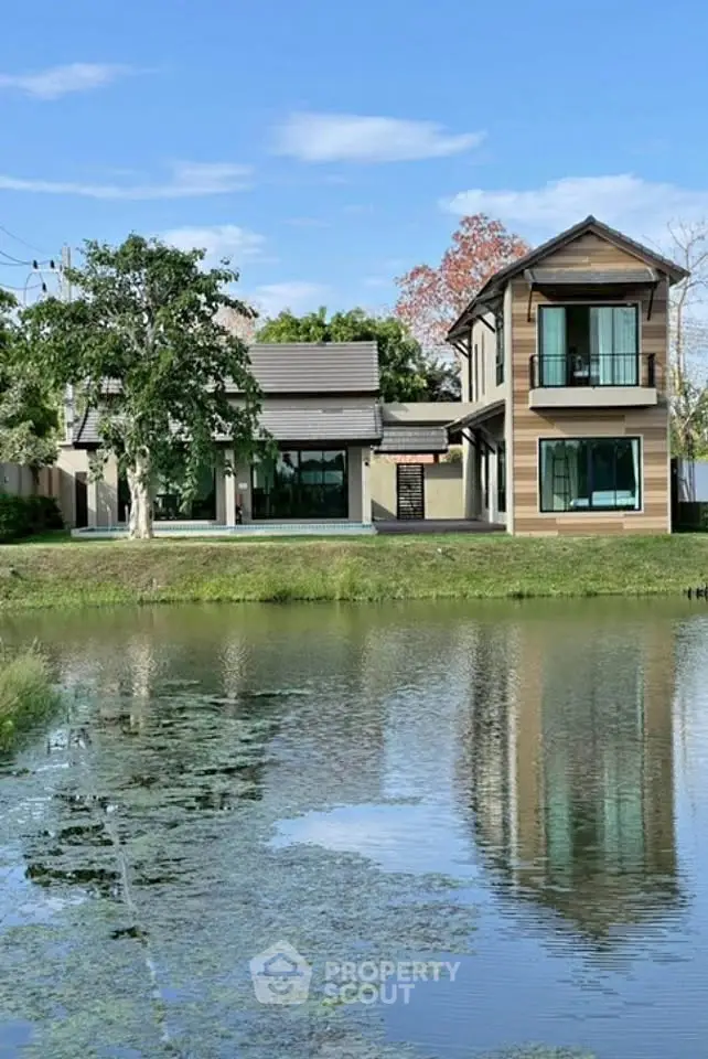 Charming lakeside house with modern architecture and lush greenery, perfect for serene living.