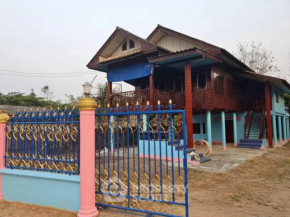 Charming traditional house with vibrant colors and ornate gate, perfect for family living.