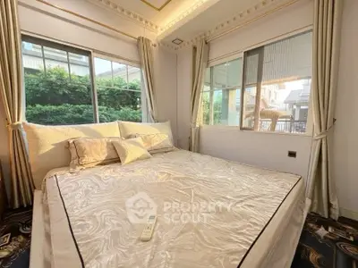 Luxurious bedroom with large windows and elegant decor, offering a serene view of the garden.
