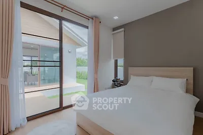 Spacious bedroom with large windows and balcony access in modern home.