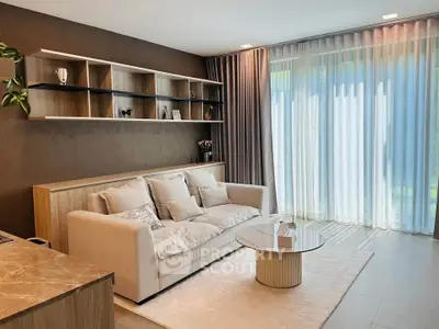 Elegant living room with modern decor, plush sofa, and floor-to-ceiling windows for natural light.