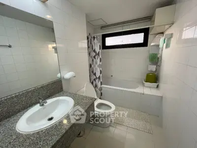 Spacious bathroom with modern fixtures and bathtub in a real estate property.