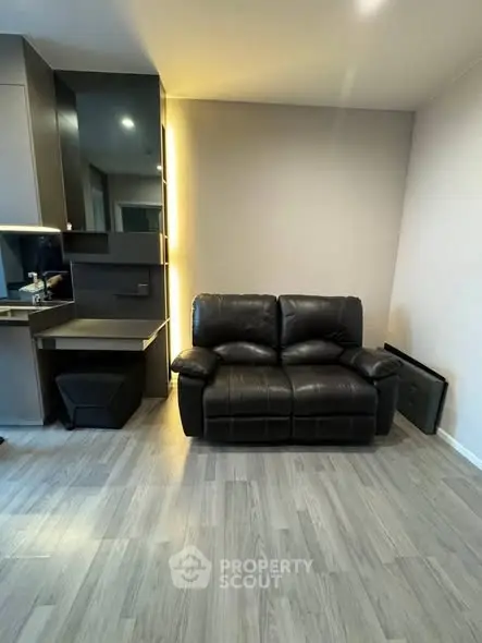 Modern living room with sleek black leather sofa and stylish decor