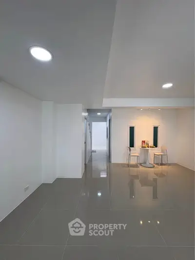 Spacious modern living area with sleek tile flooring and minimalist decor, perfect for contemporary living.