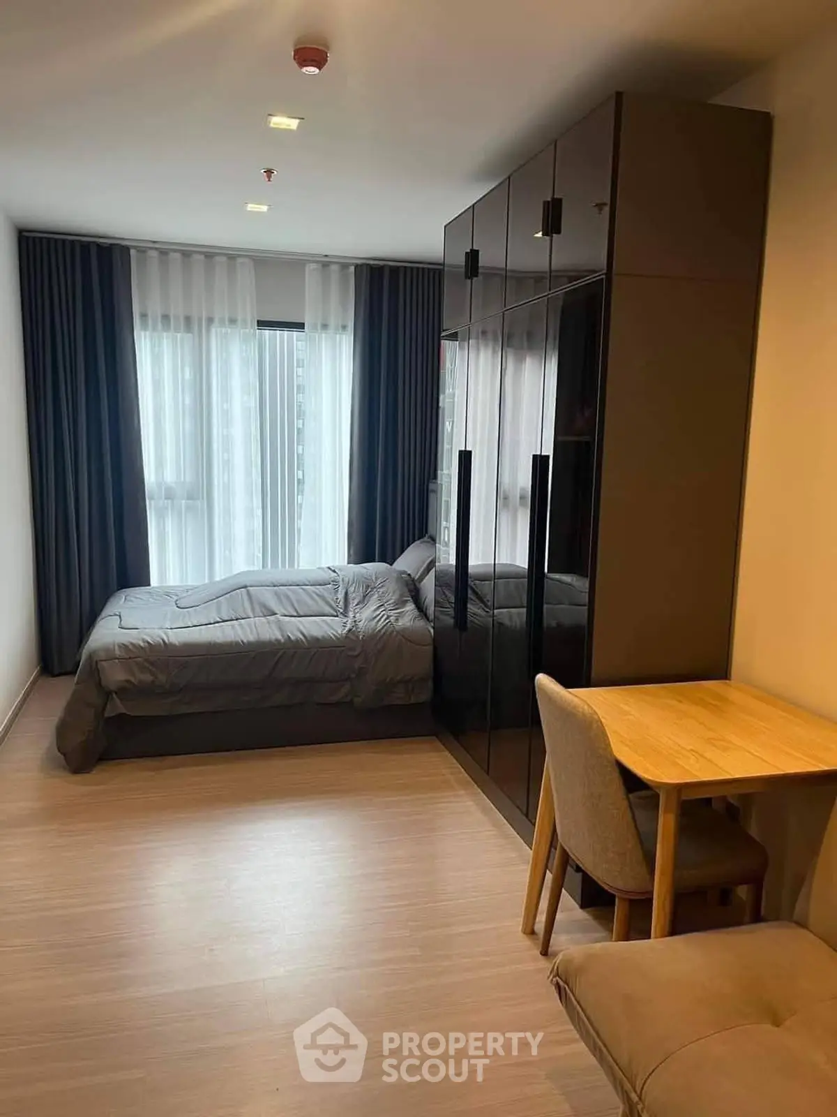 Modern bedroom with sleek wardrobe and cozy workspace