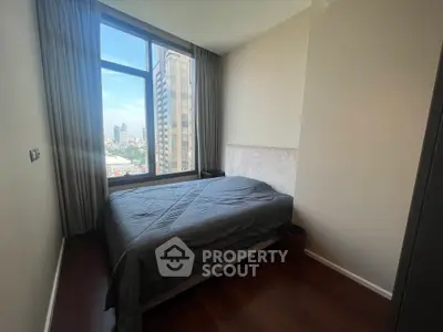 Modern bedroom with large window offering city view in high-rise apartment