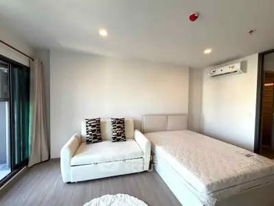 Modern bedroom with minimalist decor and balcony access in a stylish apartment.