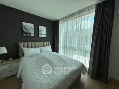 Modern bedroom with large windows and elegant decor, featuring a cozy bed and stylish curtains.