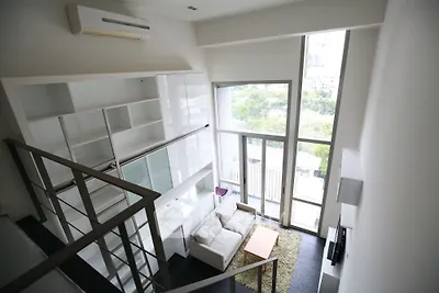 Spacious modern living room with high ceilings and large windows offering a stunning view.