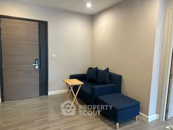 Modern living room with stylish blue sofa and wooden floor in a cozy apartment.